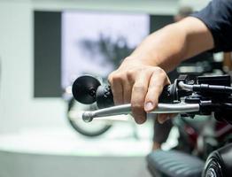 Man hand at handle motorcycle blur background,Hand catch handle bar of motorcycle photo