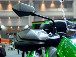 Closeup side mirror black color of motorbike sport green color in event motor show photo