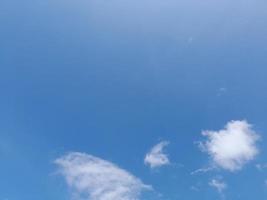 White clouds in the blue sky. Heaven and infinity. Beautiful bright blue background. Light cloudy, good weather. Curly clouds on a sunny day. photo