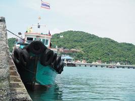 barco de viajero en el puerto de tailandia con vista a la montaña fondo océano azul foto