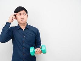 Man holding dumbbell and thinking about food lazy to work out concept photo