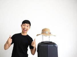 Traveler man black shirt stand and thumps up happy smile excited and vintage hat sunglasses above luggage on white isolated