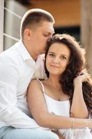 Portrait of cheerful woman and man spending time together and sitting outdoors, hugging and laughing on summer terrace, couple in love on valentine's day togetherness photo