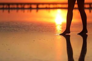 side view Footage of Beautiful Young Woman in the Swimsuit Walking on the Beach towards the Sea. Girl is Very Slim photo