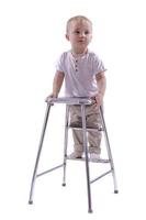 Little boy climbs onto a ladder chair. The beginning of a career concept. Funny little boy isolated on white background. photo