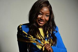 young beautiful African American fashion model with traditional African style scarf posing on gray background photo