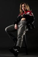 beautiful American woman posing on black background wearing black leather jacket. Fashion model wearing leather pants and jacket Fashion model wearing leather Jacket photo