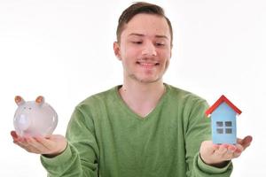 Man holding a piggy bank and a house model. Housing industry mortgage plan and residential tax saving strategy photo