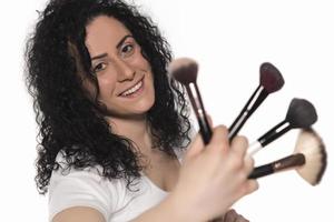 Closeup portrait of woman with makeup brush near face photo