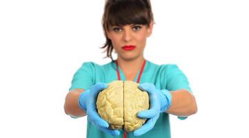 Doctora sosteniendo un modelo de cerebro humano contra el fondo blanco. foto