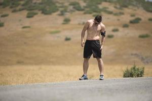 Athletic young man stretching after run in the nature. sport concept photo