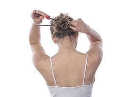 A young beautiful woman tied her hair with a rubber band photo