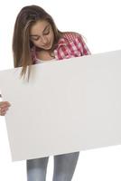 young smiling woman holding a blank sheet of paper for advertising photo