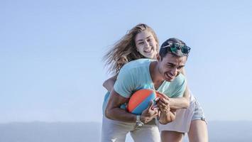 pareja jugando fútbol americano en un caluroso día de verano. sesión de fotos de pareja jugando al rugby