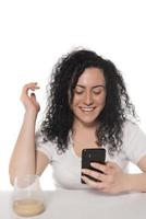 Portrait of a happy woman using mobile phone isolated over white background photo