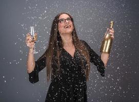 bella mujer celebrando el año nuevo con confeti y champán foto