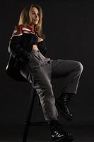 beautiful American woman posing on black background wearing black leather jacket. Fashion model wearing leather pants and jacket Fashion model wearing leather Jacket photo