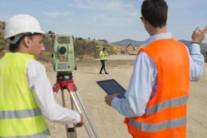 Surveyor engineer is measuring level on construction site. Surveyors ensure precise measurements before undertaking large construction projects. photo