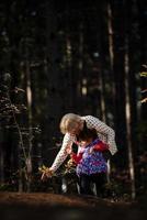 Grandmother and her autistic grand daughter enjoying holiday together outdoors, lying on green grass on blanket and smiling to camera. Leisure family lifestyle, happiness and moments. photo