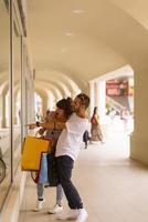 Portrait of cheerful Caucasian young couple man and woman holding many paper bags after shopping while walking and talking on street. Happy family couple with packages outdoor. Buying concept photo