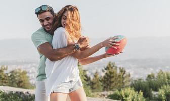 Couple playing American football on hot summer day. Couple playing Rugby photo shoot