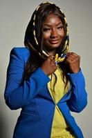 young beautiful African American fashion model with traditional African style scarf posing on gray background photo