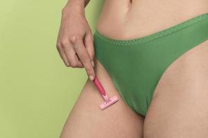 woman in panties shaved her crotch with razor photo