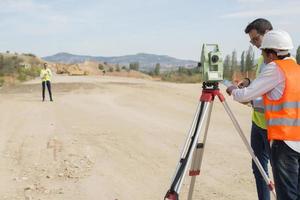 el ingeniero topógrafo está midiendo el nivel en el sitio de construcción. los topógrafos aseguran mediciones precisas antes de emprender grandes proyectos de construcción. foto