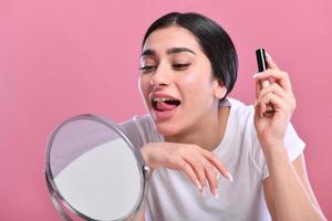 mujer haciendo maquillaje, mirando al espejo. foto