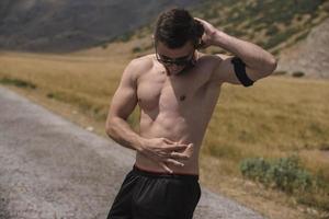 Athletic young man stretching after run in the nature. sport concept photo