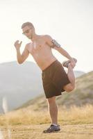 Athletic young man stretching after run in the nature. sport concept photo