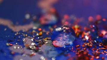 Close-up Of water drop with glitter on it in different colorful loghts in Karachi Pakistan 2022 photo