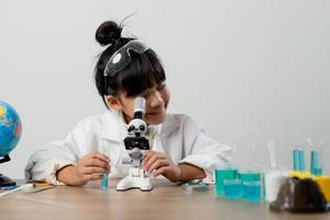 education, science, chemistry and children concept - kids or students with test tube making experiment at school laboratory photo