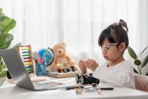Asia students learn at home in coding robot cars and electronic board cables in STEM, STEAM, mathematics engineering science technology computer code in robotics for kids concept. photo