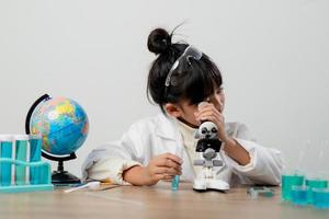 education, science, chemistry and children concept - kids or students with test tube making experiment at school laboratory photo