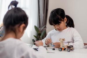 Asia students learn at home in coding robot cars and electronic board cables in STEM, STEAM, mathematics engineering science technology computer code in robotics for kids concept. photo