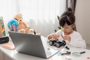 Asia students learn at home in coding robot cars and electronic board cables in STEM, STEAM, mathematics engineering science technology computer code in robotics for kids concept. photo