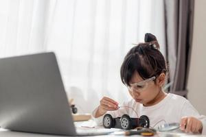 Asia students learn at home in coding robot cars and electronic board cables in STEM, STEAM, mathematics engineering science technology computer code in robotics for kids concept. photo