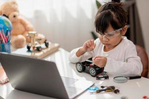 Asia students learn at home in coding robot cars and electronic board cables in STEM, STEAM, mathematics engineering science technology computer code in robotics for kids concept. photo