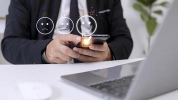 Customer service evaluation concept. using a smartphone is pressing face emoticon smiling in satisfaction on virtual touch screen. photo