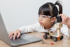 Asia students learn at home in coding robot cars and electronic board cables in STEM, STEAM, mathematics engineering science technology computer code in robotics for kids concept. photo