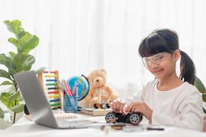 Asia students learn at home in coding robot cars and electronic board cables in STEM, STEAM, mathematics engineering science technology computer code in robotics for kids concept. photo