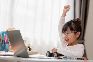 Asia students learn at home in coding robot cars and electronic board cables in STEM, STEAM, mathematics engineering science technology computer code in robotics for kids concept. photo