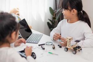 Asia students learn at home in coding robot cars and electronic board cables in STEM, STEAM, mathematics engineering science technology computer code in robotics for kids concept. photo