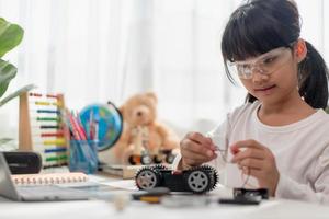 Asia students learn at home in coding robot cars and electronic board cables in STEM, STEAM, mathematics engineering science technology computer code in robotics for kids concept. photo