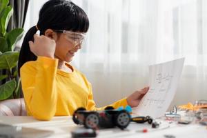 Asia students learn at home in coding robot cars and electronic board cables in STEM, STEAM, mathematics engineering science technology computer code in robotics for kids concept. photo