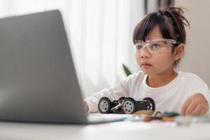 Asia students learn at home in coding robot cars and electronic board cables in STEM, STEAM, mathematics engineering science technology computer code in robotics for kids concept. photo