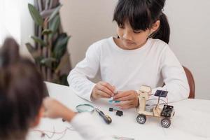 Asia students learn at home in coding robot cars and electronic board cables in STEM, STEAM, mathematics engineering science technology computer code in robotics for kids concept. photo