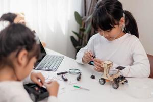 Asia students learn at home in coding robot cars and electronic board cables in STEM, STEAM, mathematics engineering science technology computer code in robotics for kids concept. photo