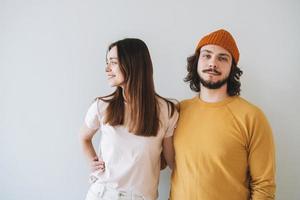 Portrait of smiling couple young family hipsters against gray wall photo